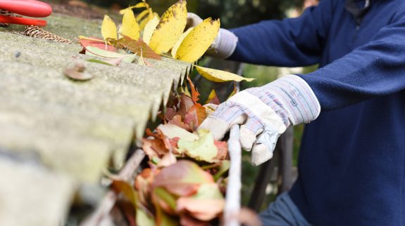 Person cleaning gutters