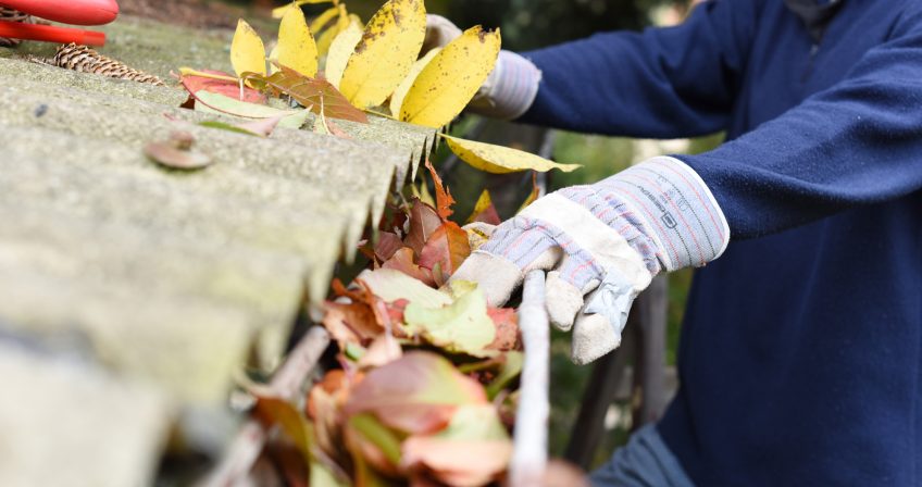 Person cleaning gutters