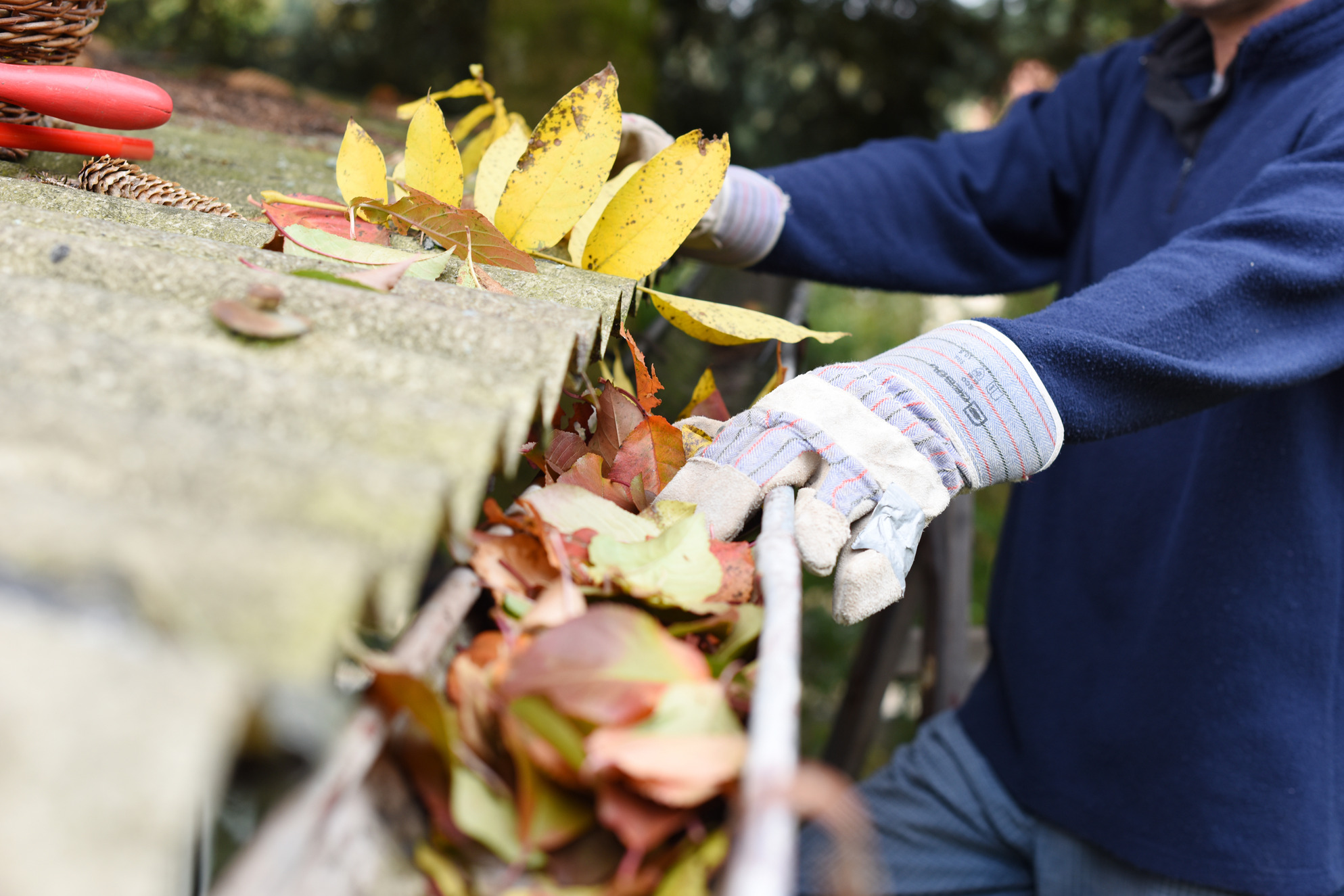 Person cleaning gutters